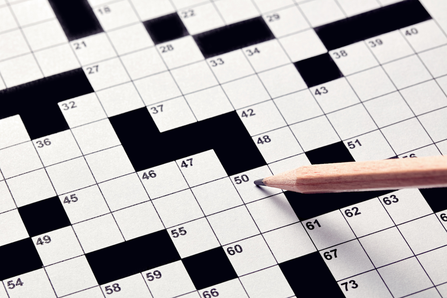 A pencil over a blank crossword puzzle. Depicts an example of activities that promote cognitive health in assisted living.